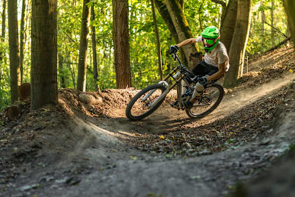 A person is riding a mountain bike at Woodland Place Apartments, Langford, BC, L4H 3P6