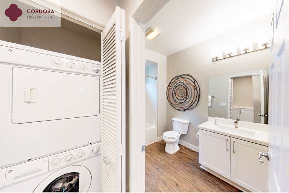 A white washing machine is in a small laundry room.