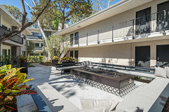 A patio with a table and chairs is surrounded by buildings.