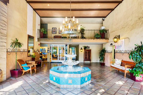 a lobby with a fountain and a chandelier