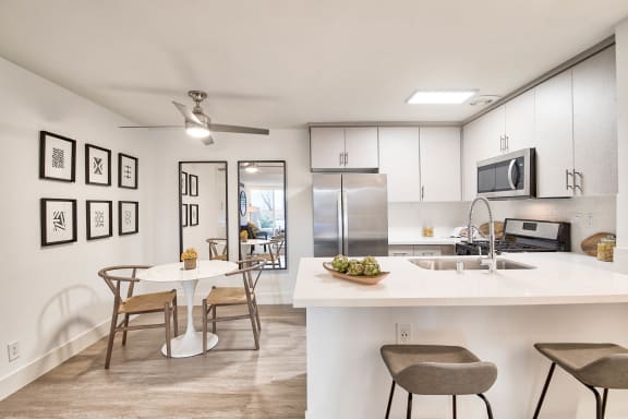 an open kitchen and dining area with a table and chairs at The Meadows Apartments, Culver City , CA 90230