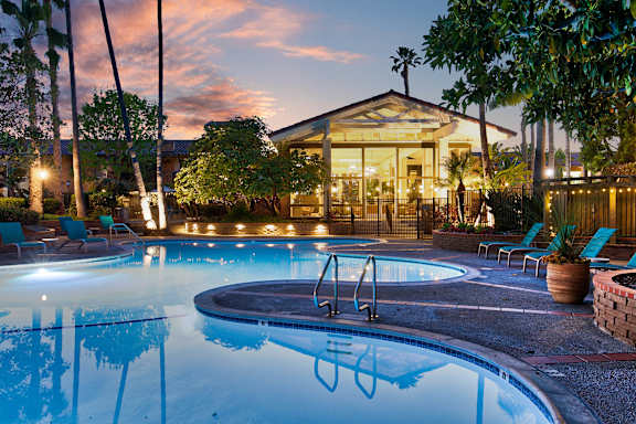 A pool with a hot tub and a house in the background. at Mediterranean Village Costa Mesa, Costa Mesa