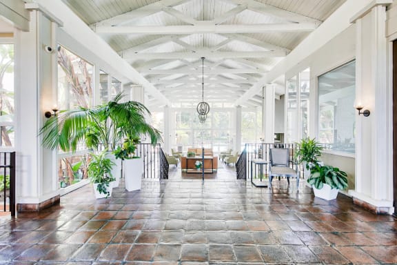 a large room with tables and plants in it  at Mediterranean Village Costa Mesa, Costa Mesa, CA, 92626