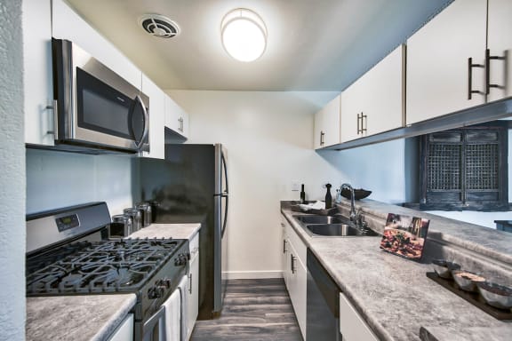 a kitchen with a stove and a sink and a refrigerator  at Mediterranean Village Costa Mesa, Costa Mesa, 92626