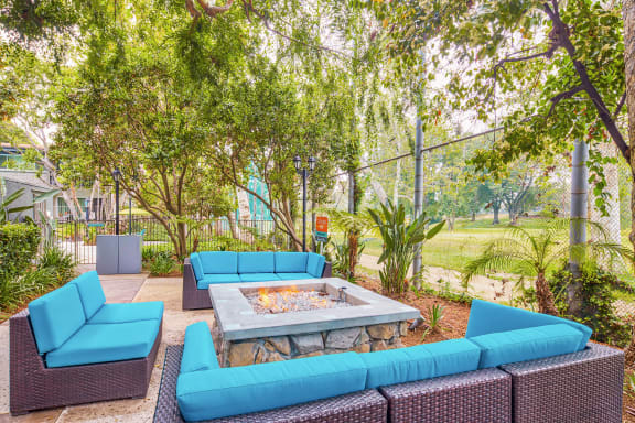 a lounge area with blue couches and a fire pit