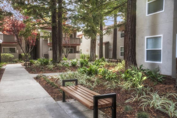 a wooden bench sitting in front of a building at Valley Plaza Villages, Pleasanton, 94566