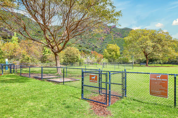 a dog park with a fence and a tree  at Mission Hills, California