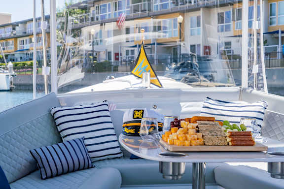 A boat with a table set for a meal and a striped pillow.