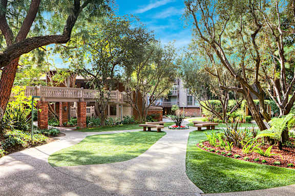 A tree-lined walkway leads to a building.