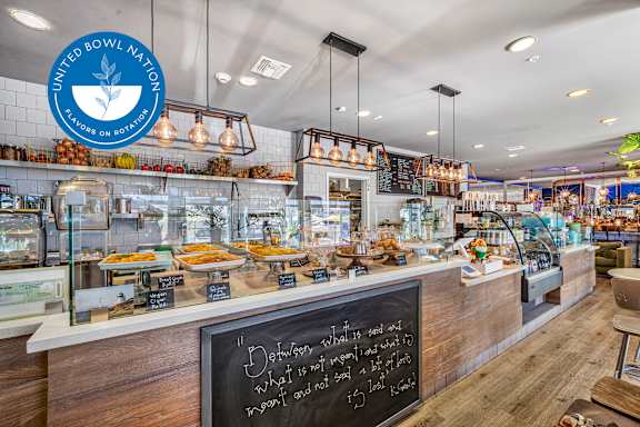 A bakery interior with a chalkboard sign that says "Dear customers, what to order and what not to order?".