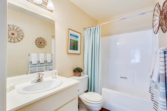 A bathroom with a white sink, toilet, and bathtub.