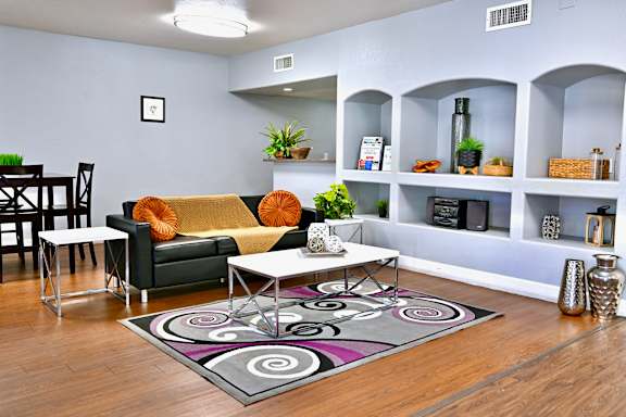 A living room with a couch, chairs, and a rug.