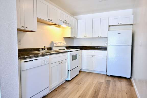 A kitchen with white appliances and cabinets.