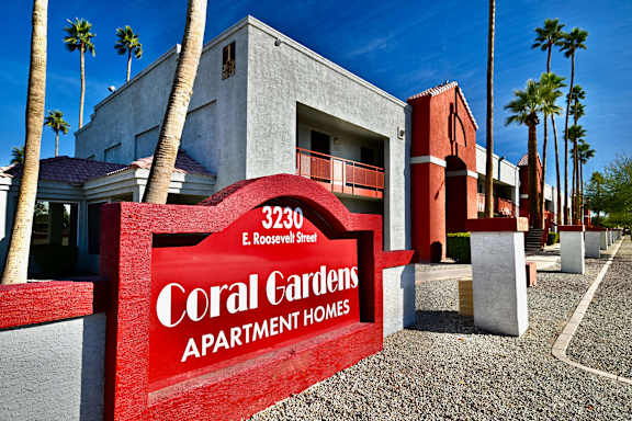 A red sign that says Coral Gardens Apartment Homes.
