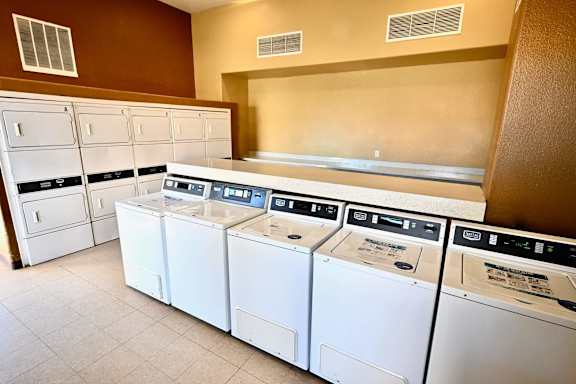 A row of white washing machines in a laundromat.
