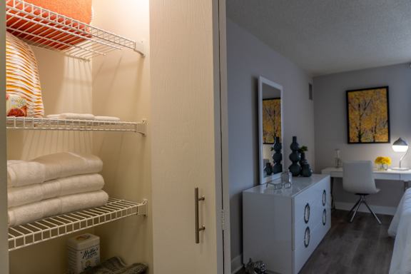 A bathroom with a white chair and a white cabinet.