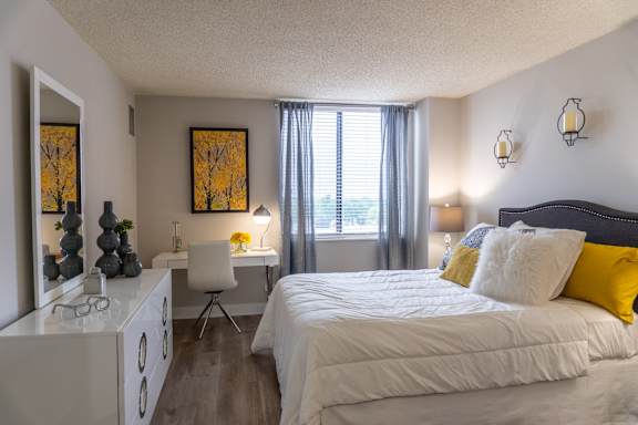 A bedroom with a large bed and a white dresser.