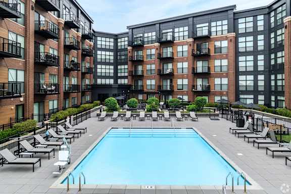 Outdoor pool with lounge seating and courtyard views at TLC Grand Apartments, Illinois, 60015