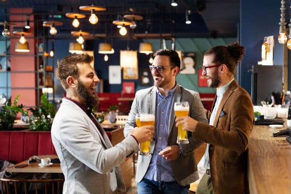 three men drinking beer in a bar