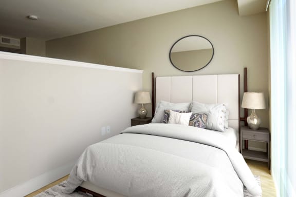 a bedroom with a white bed and a round mirror