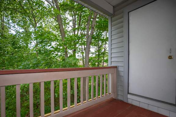 A white door is on the right side of a porch. at The Northway at Clifton Park Apartments, Clifton Park at The Northway at Clifton Park Apartments, Clifton Park