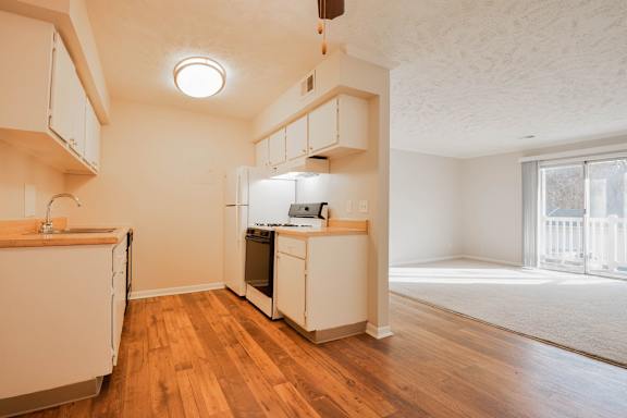 A kitchen with wooden floors and white appliances.
