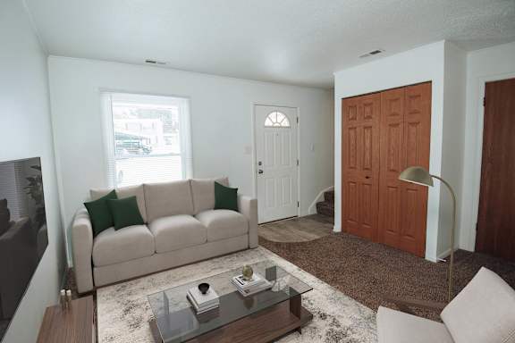 A living room with a couch, coffee table, and two doors.