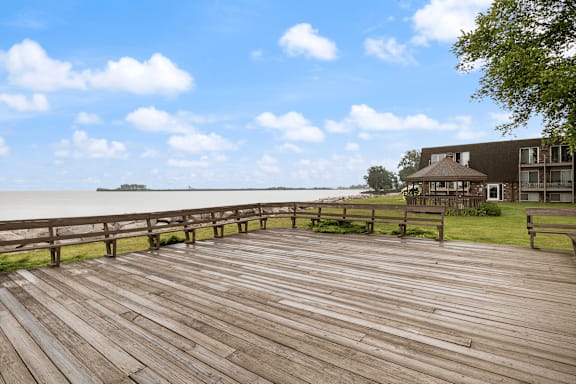 A wooden boardwalk leads to a house by the water.