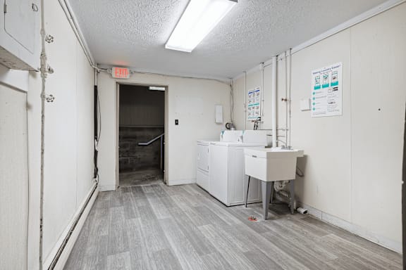 A white wall with a red exit sign on it.