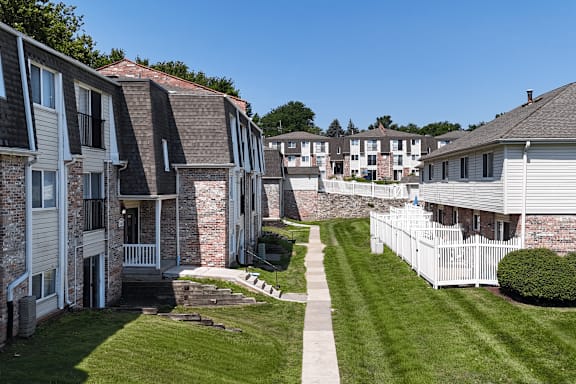 A sunny day in a quiet residential area with houses and a clear blue sky.