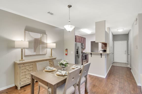 a rendering of a living room with a kitchen in the background at Ashford Place Apartment Homes, Flowood, MS 39232