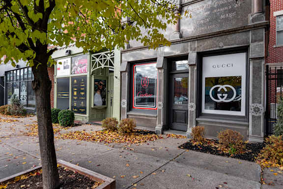 Luxury retail storefronts along tree lined sidewalk at The Granite Works Apartments , Buffalo