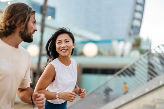 A man and a woman are running together outdoors.