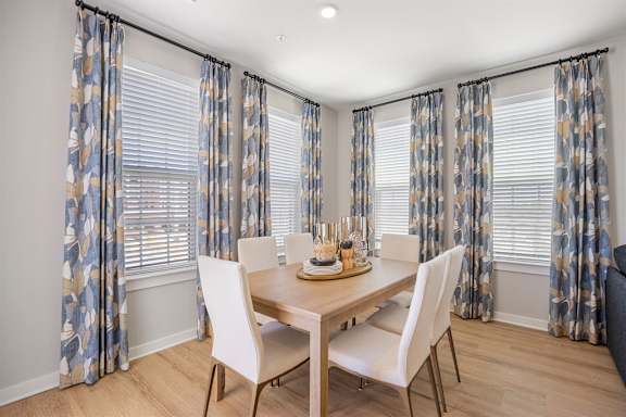 A dining room with a table set for four.