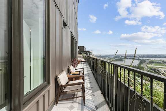 a balcony with a table and chairs and a view of a city