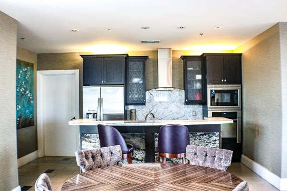 a kitchen and dining room with black cabinets at The Heights at Park Lane, Dallas, Texas