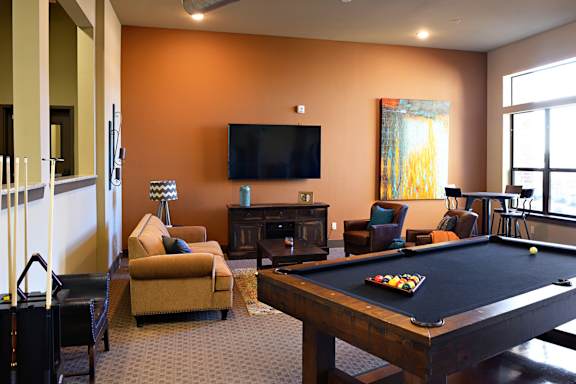 a living room with a pool table and a television