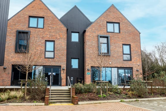 the front of a red brick house with black windows