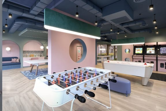 a recreation room with a foosball table and a pool table