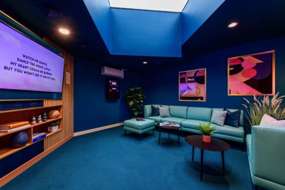 a living room with couches and a tv in a blue room