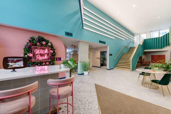 a lobby with a pink and blue bar and a staircase