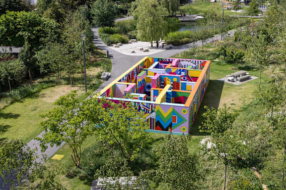A colorful building with a playground in front of it.