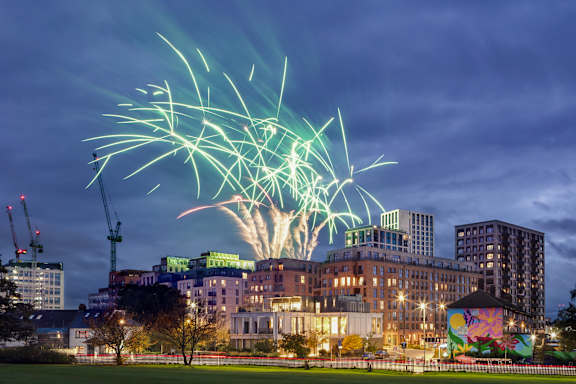 A firework display over a cityscape at night.