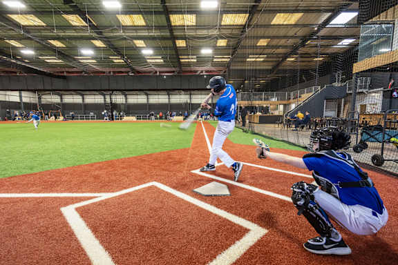 A baseball game is in progress with a batter, catcher and umpire in position.