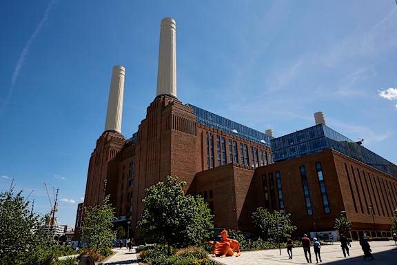 A large building with two tall chimneys and a blue roof.