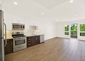 Thumbnail 33 of 41 - A kitchen with wooden floors and stainless steel appliances.