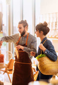 a man and a woman in a grocery store with a basket of food
