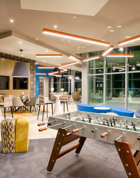 a game room with a foosball table and a large window at Vista Brooklynn Apartments, Jacksonville