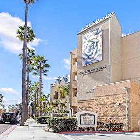 A modern building with a parking lot in front.at Costa Verde Village Apartments, San Diego, CA
