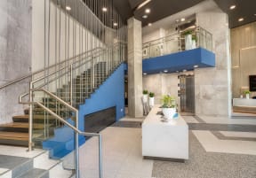 the lobby of a building with stairs and a blue staircase at Vista Brooklynn Apartments, Florida